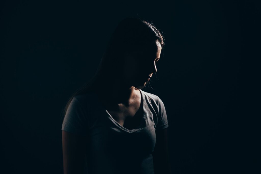 Zdjęcie kobiety na ciemnym tle. Nocne ataki paniki.